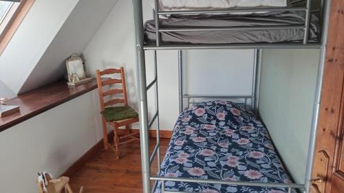 a room with two bunk beds and a chair at Au cottage normand in Saint-James