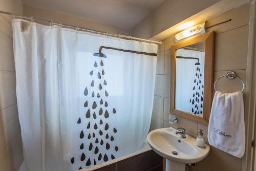 a bathroom with a shower curtain and a sink at Eltheo Villas in Agios Nikitas