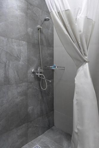 a shower with a shower curtain in a bathroom at Guest House “Aura” in Cholpon-Ata