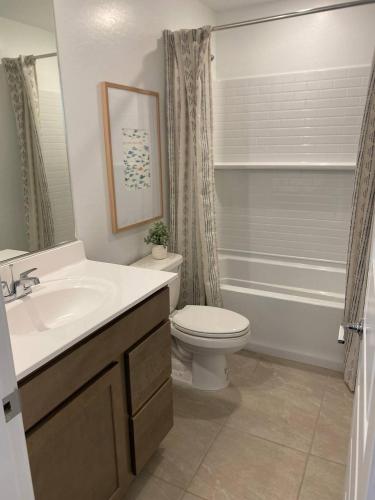 a bathroom with a toilet and a sink and a tub at Todd's Relaxation Place in Maricopa