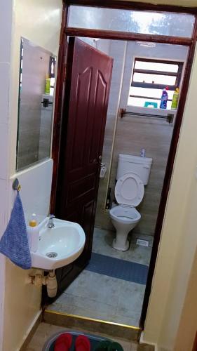 a bathroom with a toilet and a sink at Cozy cloud in Ruiru