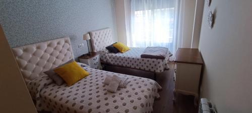 a small room with two beds and a window at Calle Maceiras, 1 - 1B in Combarro