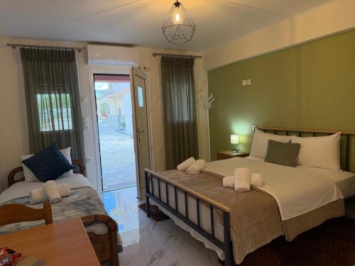 a bedroom with two beds and a door to a patio at Flo's Apartments in Missolonghi