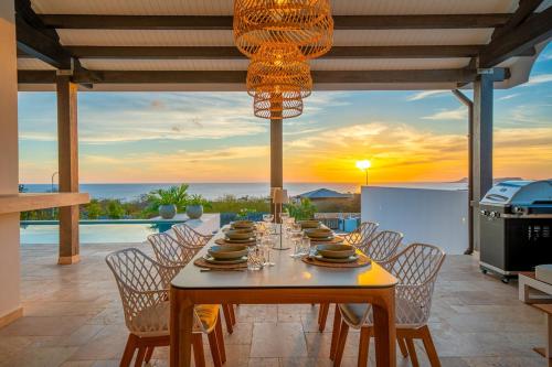a dining room with a table and a view of the ocean at Luxe Villa met Panoramisch Zeezicht op Bonaire - Kas Ubuntu in Kralendijk