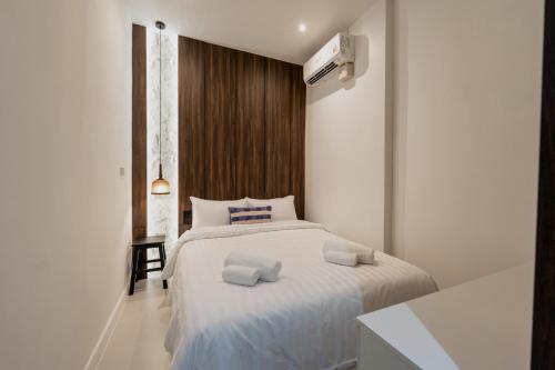 a bedroom with a white bed with two towels on it at Continuum Hotel Udonthani in Udon Thani