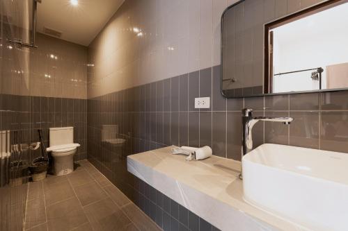 a bathroom with a tub and a toilet and a sink at Continuum Hotel Udonthani in Udon Thani