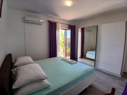 a bedroom with a bed and a large mirror at Apartmani Kate, Plat in Mlini
