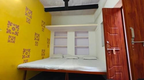 a bunk bed in a room with a yellow wall at singh homestay in Varanasi