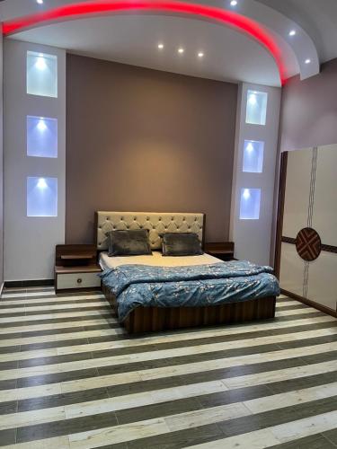 a bedroom with a bed and a red ceiling at شالهيات ريست 2 in Hail