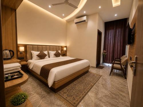 a bedroom with a bed and a chair in a room at Hotel JB Square Ayodhya Near Ram Mandir, Airport & Ayodhya Cantt in Ayodhya