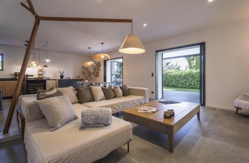 a living room with two couches and a table at Villa bord de mer piscine, jacuzzi in Hyères