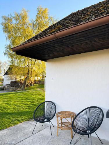 two chairs and a table next to a building at Chaloupka na Perkách in Zahrádky