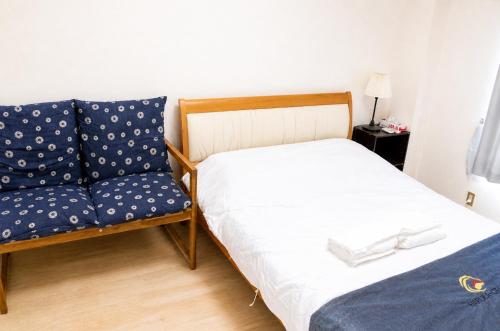 ein Bett und eine Couch in einem Zimmer in der Unterkunft otani 201 in Osaka