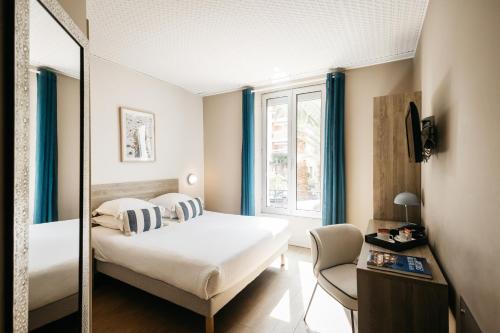 a hotel room with a bed and a mirror at Hôtel Le Petit Castel in Antibes