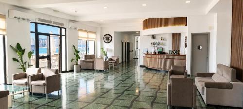 eine Lobby mit Stühlen und einer Bar in einem Gebäude in der Unterkunft Hotel Sicania in Cullera