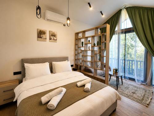a bedroom with a large bed with towels on it at Azure Olive Collection in Ulcinj