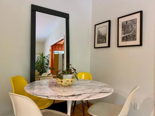 a dining room with a table and yellow chairs at Mid-Century Gem Creekside King Beds Near UNC in Chapel Hill