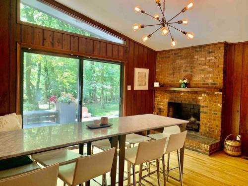 a dining room with a table and chairs and a fireplace at Mid-Century Gem Creekside King Beds Near UNC in Chapel Hill