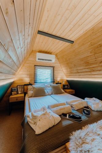 a large bed in a room with a wooden ceiling at Maroska Pine in Kismaros