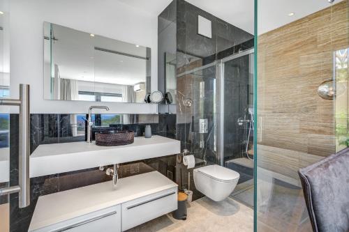 a bathroom with a sink and a toilet and a shower at Villa Luca in Seget Vranjica