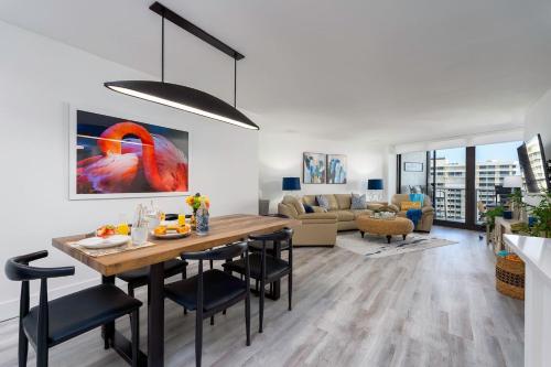 a dining room and living room with a table and chairs at Waterfront Condo Beach Access & Pool Luxury in Marco Island