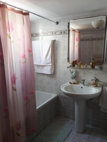 a bathroom with a sink and a shower curtain at mastic flavored sweet in Chios