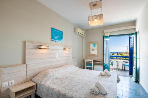 a bedroom with a bed and a balcony at Blue Sea Hotel in Amoopi