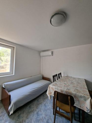 a room with a bed and a table and a window at Rose Zaglav in Zaglav