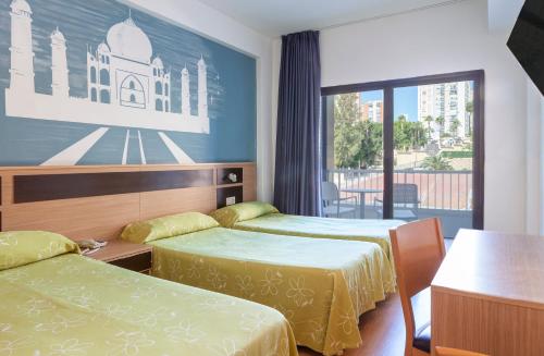 ein Hotelzimmer mit zwei Betten und einem Fenster in der Unterkunft Hotel Golden in Benidorm