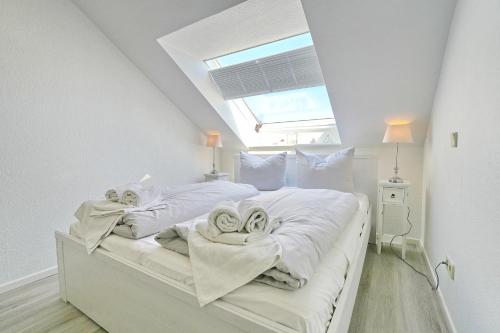 a bedroom with a bed with white sheets and towels at Residenz Ostseestrand Appartement 29 in Scharbeutz