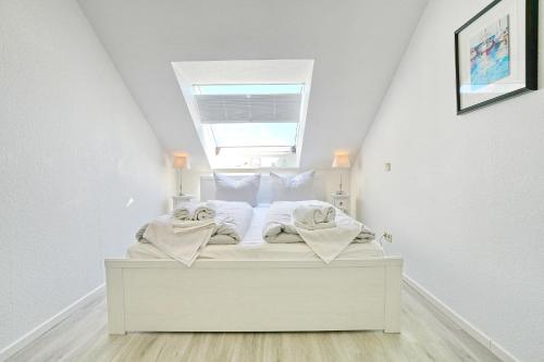 a white bed with towels on it in a room at Residenz Ostseestrand Appartement 29 in Scharbeutz