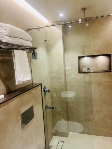a bathroom with a shower with a glass door at Hotel Vedic Roots in Varanasi