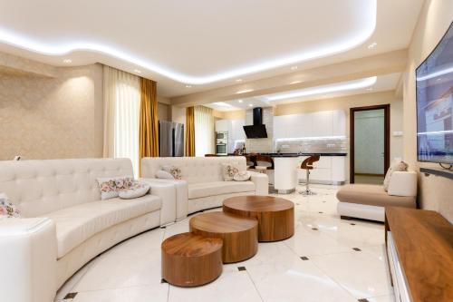 a living room with white couches and a table at Cityscape Luxury Apartment in Tbilisi City