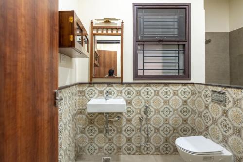 a bathroom with a sink and a toilet at Nadhima Villas in Kumbakonam