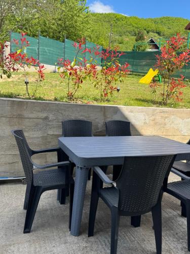 a black table and chairs with a garden in the background at House Sarajka in Sarajevo