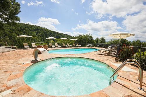 a swimming pool with a water fountain at Il Castelluccio Country Resort Restaurant & SPA in Barberino di Mugello