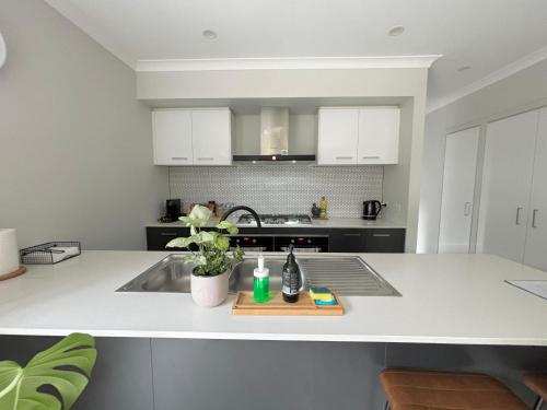 a kitchen with a sink and a counter top at Cozy room with an Ensuite in Clyde North