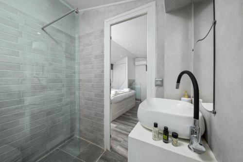 a bathroom with a sink and a shower with a mirror at The Loft by Life Homes in Corfu