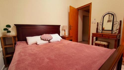 a bedroom with a large bed with a red blanket at AsteriA 3D House Inn in Pano Arodes