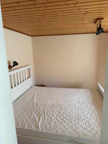 a bed in a room with a wooden ceiling at Gemütlicher Bungalow in Canow mit Terrasse, Hof und Seenähe in Wustrow