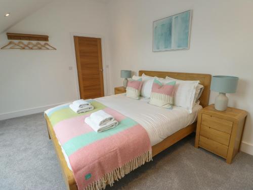a bedroom with a large bed with towels on it at Glynllifon 7 in Llanallgo