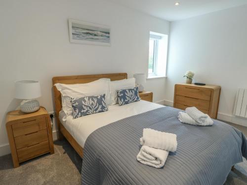 a bedroom with a bed with towels on it at Glynllifon 5 in Llanallgo