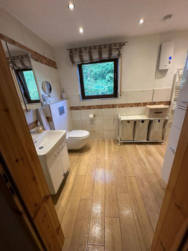 a bathroom with a toilet and a sink and a window at Nürburgring Eifelhaus in Baar