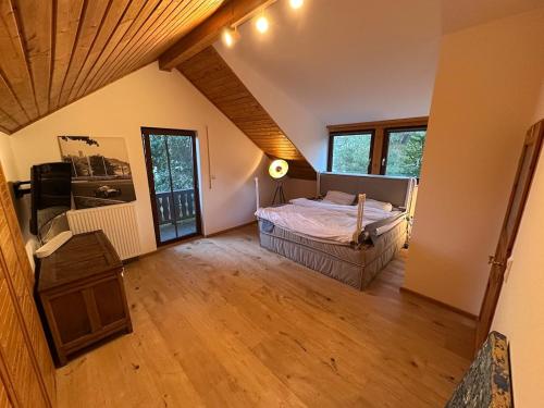 a bedroom with a bed and a wooden floor at Nürburgring Eifelhaus in Baar