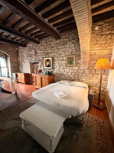 a bedroom with a bed and a stone wall at Residenza Via Felicchi 10 in Gubbio