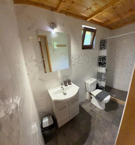 a white bathroom with a sink and a toilet at Mani Sea View Rooms in Gythio