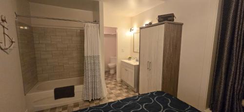 a bathroom with a shower and a toilet and a sink at Le Pirate Motel et Camping in Cap-Chat