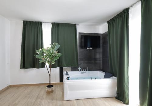 a bathroom with a white tub and green curtains at Viroga Suite Apartments in Castel Volturno