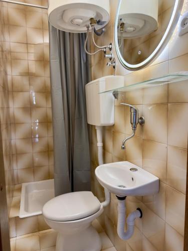 a small bathroom with a toilet and a sink at Rooms Nada in Senj