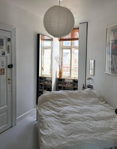 a bedroom with a bed and a pendant light at Bright apartment in central Copenhagen in Copenhagen